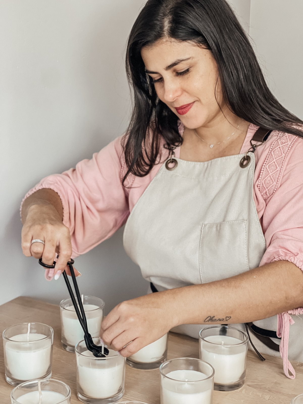 Cinara Pavesi trimming candle wicks at her workbench